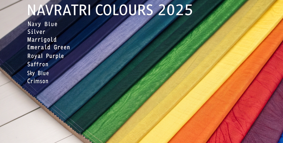 Colorful fabric display showing the nine Navratri colours 2025 (नवरात्रि रंग) including navy blue, marigold, emerald green, saffron, and crimson, each linked to Devi worship.
